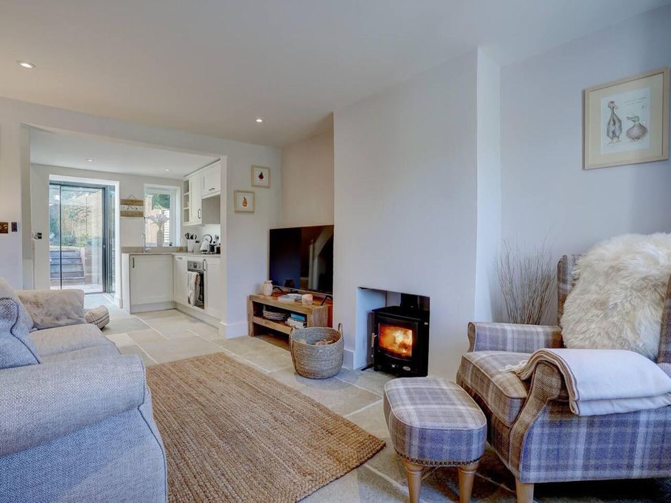 A living room with a sofa and television at 1 Bed Cottage Sleeps 2 with Hot Tub Pets Welcome Great Massingham