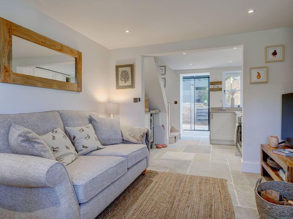 A living room with a sofa and a television at 1 Bed Cottage Sleeps 2 with Hot Tub Pets Welcome Great Massingham