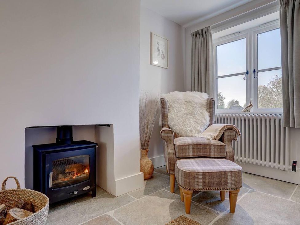 A living room featuring an armchair and a wood stove at 1 Bed Cottage Sleeps 2 with Hot Tub Pets Welcome, Great Massingham