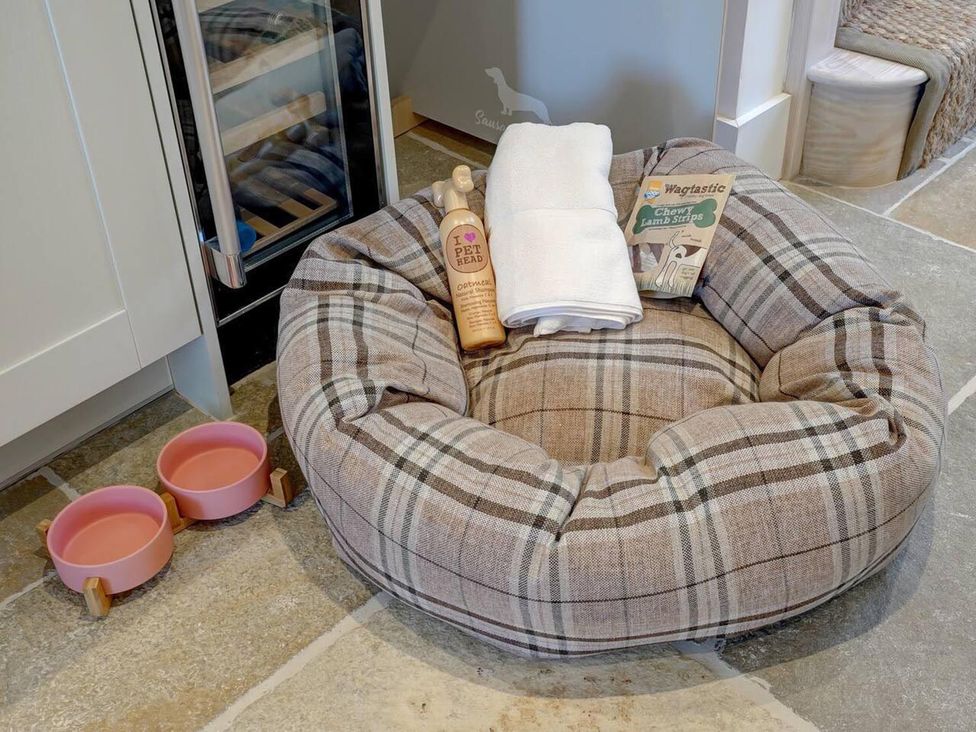 A dog bed with towels and supplies at 1 Bed Cottage Sleeps 2 with Hot Tub Pets Welcome in Great Massingham