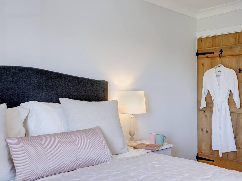 A bedroom with a bed and a lamp at 1 Bed Cottage Sleeps 2 with Hot Tub Pets Welcome in Great Massingham