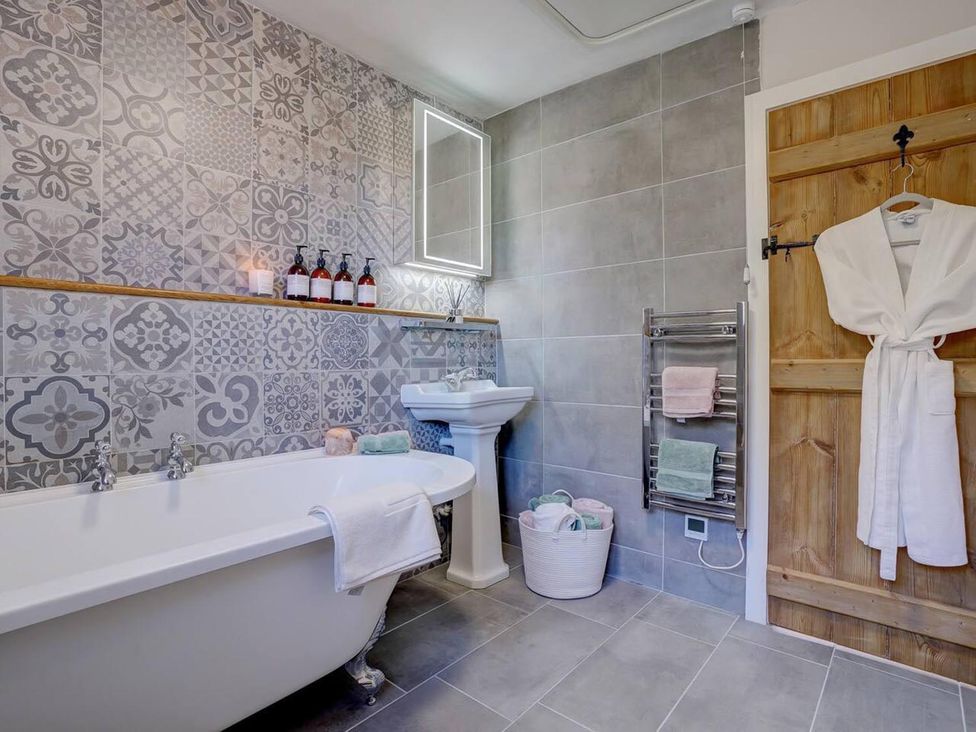 A bathroom with a bathtub and sink at 1 Bed Cottage Sleeps 2 with Hot Tub Pets Welcome in Great Massingham