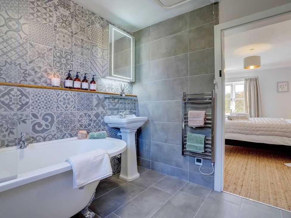 A bathroom with a bathtub and sink at 1 Bed Cottage Sleeps 2 with Hot Tub Pets Welcome, Great Massingham
