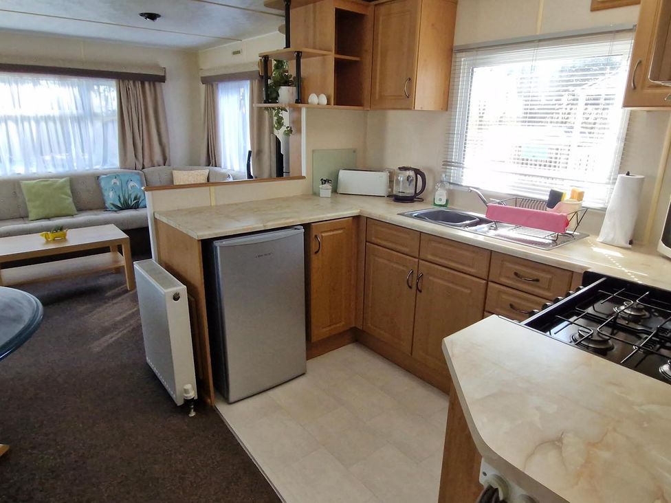 A kitchen with a refrigerator, stove, and sink at Woodland View Dog Friendly Nr Sutton on Sea Thurlby near Alford