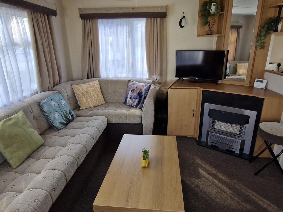 A living room with a sofa and television at Woodland View Dog Friendly Nr Sutton on Sea Thurlby near Alford
