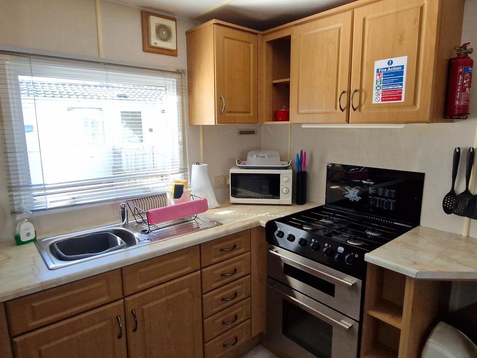 A kitchen with a sink, oven, and microwave at Woodland View Dog Friendly Nr Sutton on Sea Thurlby near Alford