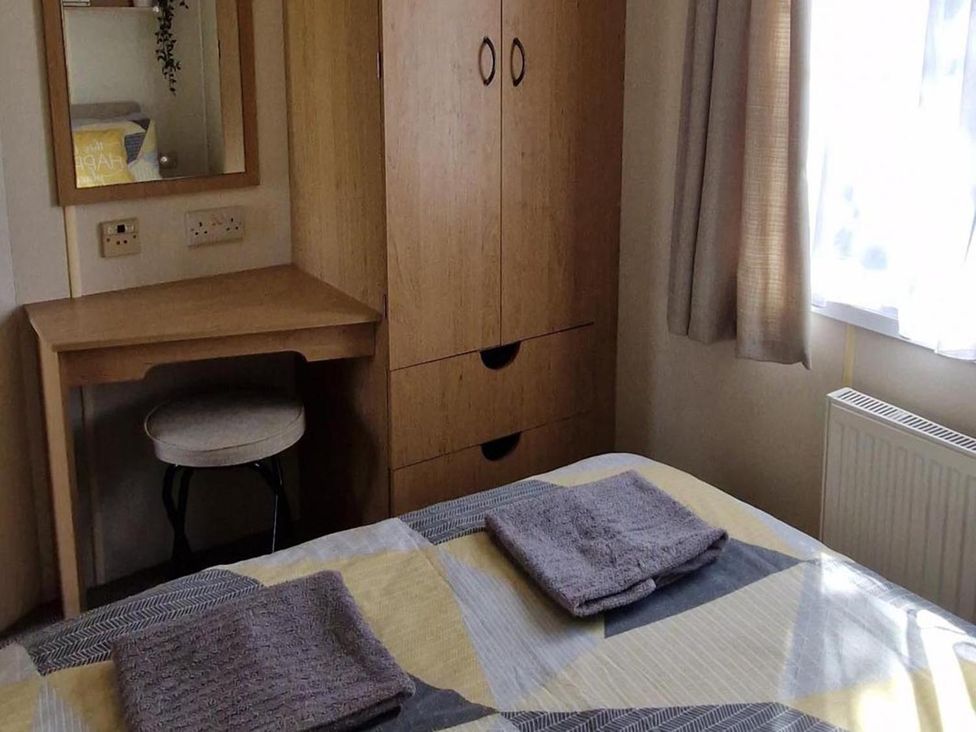 A bedroom with a bed and wardrobe at Woodland View Dog Friendly Nr Sutton on Sea, Thurlby near Alford