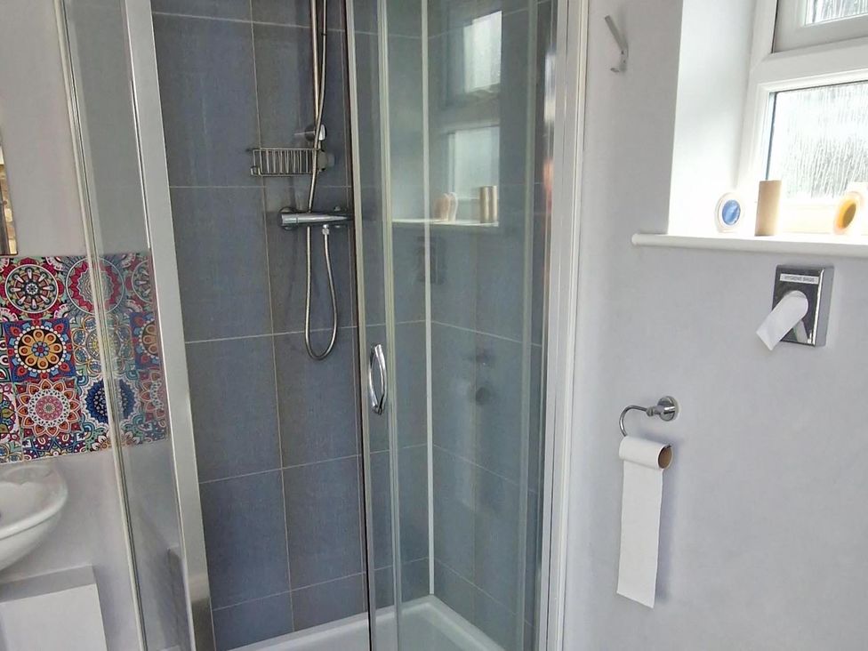 A shower enclosure with a sink in the bathroom at Woodland View Dog Friendly Nr Sutton on Sea Thurlby near Alford
