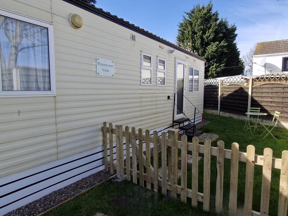 A mobile home with a fenced area and outdoor seating at Woodland View Dog Friendly Nr Sutton on Sea, Thurlby near Alford
