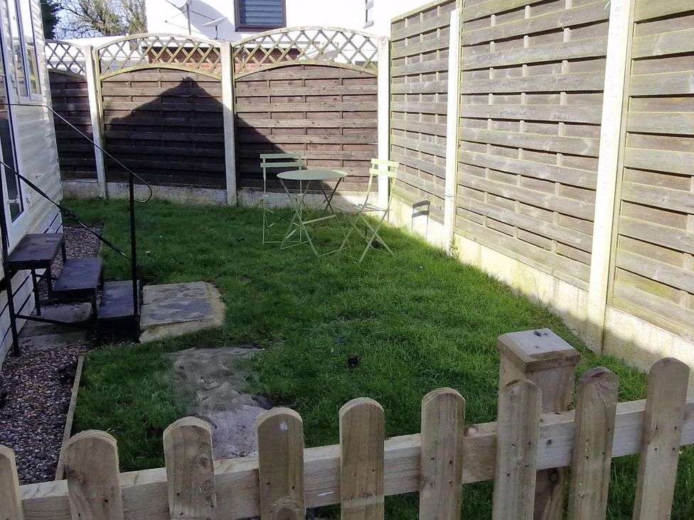 A garden with a table and chairs at Woodland View Dog Friendly Nr Sutton on Sea Thurlby near Alford