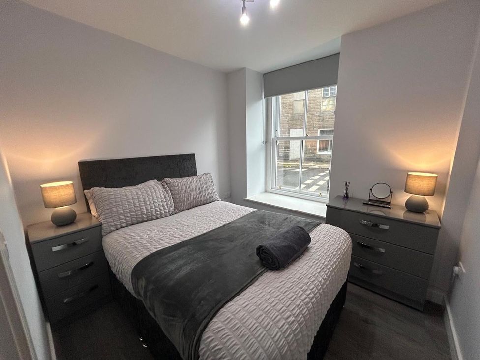 A bedroom with a double bed and a nightstand at Wick Harbour Apt  2 Bed  Fast WiFi  NC500, Wick, Caithness