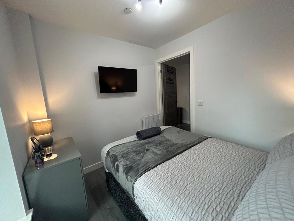A bedroom with a bed and television at Wick Harbour Apt  2 Bed  Fast WiFi  NC500 in Wick, Caithness