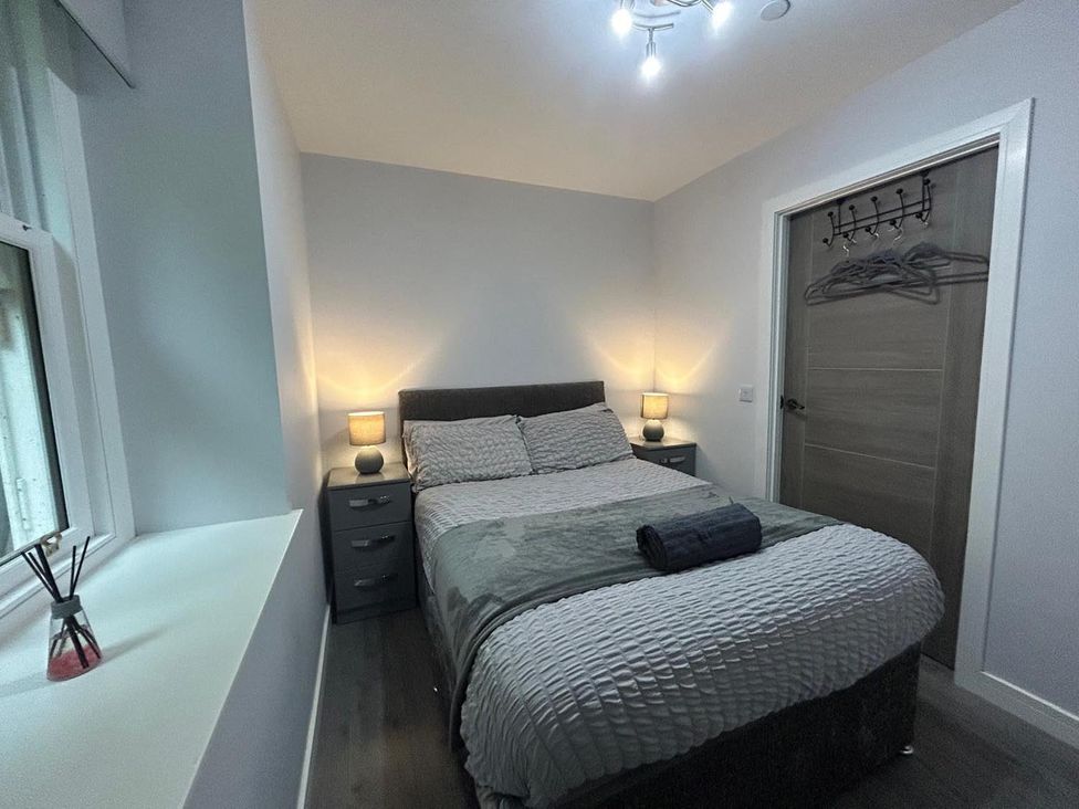 A bedroom with a bed and nightstand at Wick Harbour Apt 2 Bed Fast WiFi NC500 in Wick, Caithness