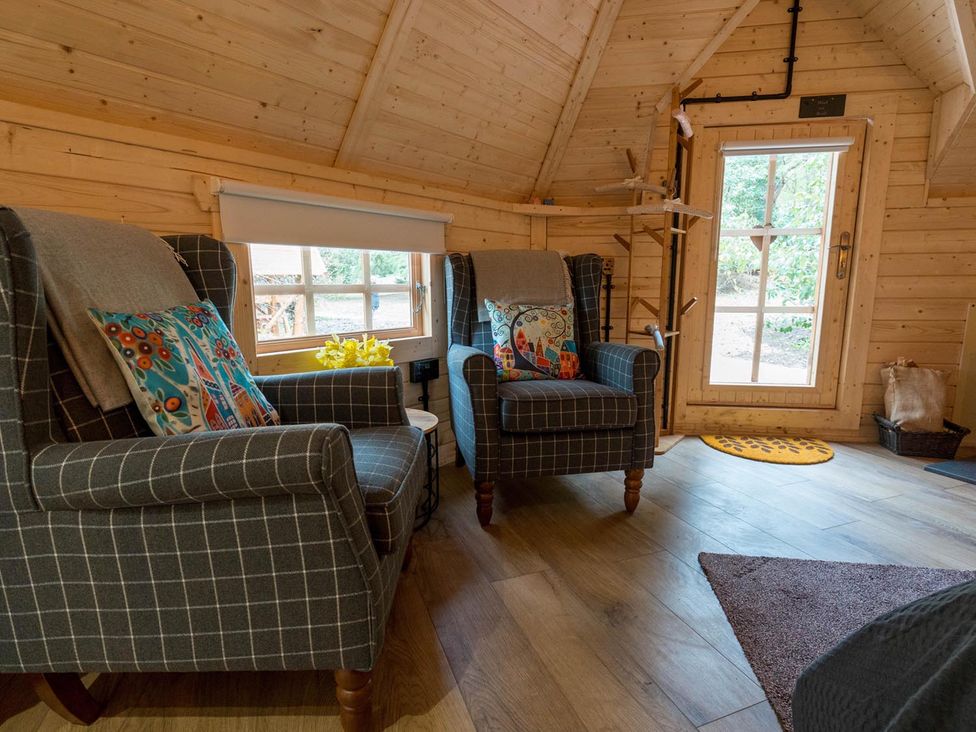 A snug with two armchairs and a window at Punch Tree Cabins Outdoor Bath Wood Burner near Carluke