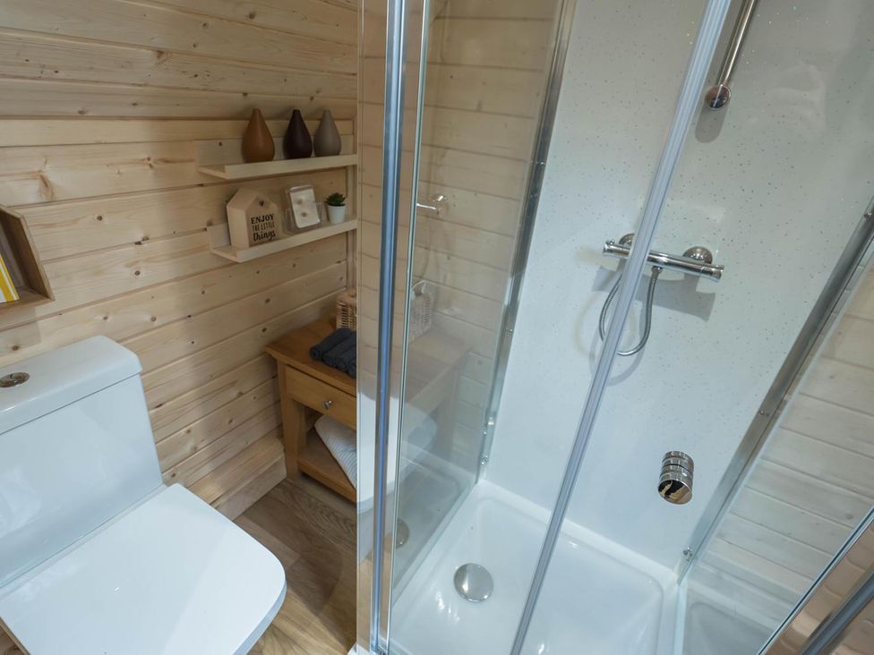 A bathroom featuring a shower and toilet at Punch Tree Cabins Outdoor Bath Wood Burner Carluke near Larkhall