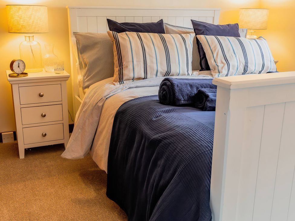 A bedroom with a bed and bedside table at 
