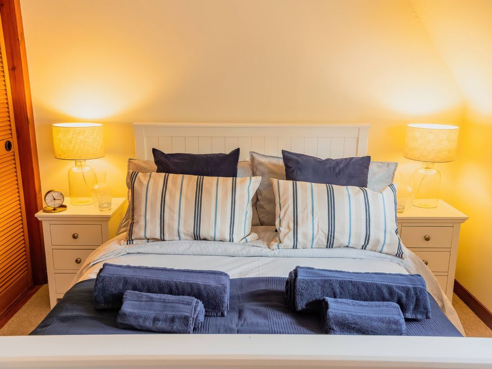 A bedroom with a bed, bedside table, and lamp in Lairg