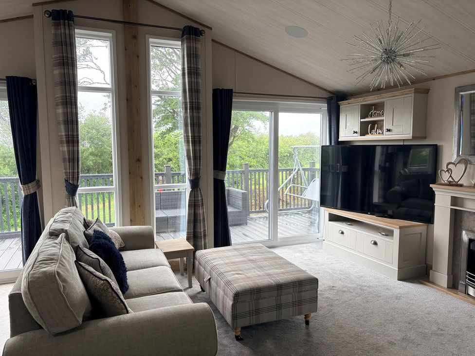 A living room with a sofa and television at Harrogate Lodge Sleeps4 South Facing Decking Lufflands Caravan Park near Holsworthy