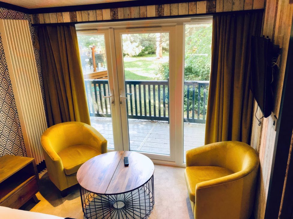 A living room with two armchairs and a coffee table at Sandy Balls Holiday Park Pet Friendly Lodge in Godshill, Hampshire