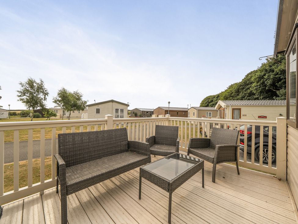 A seating area with chairs and a table at a caravan park in Tunstall, North Yorkshire