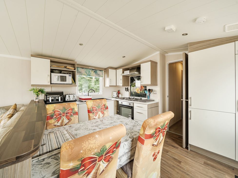 A kitchen with appliances and dining area at the property in Tunstall, North Yorkshire