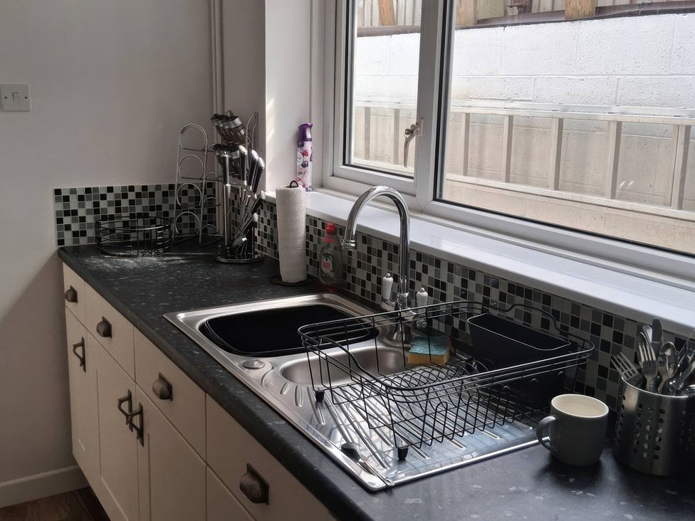 A kitchen with sink and dish rack at The Old Barn in Newbridge, Caerffili