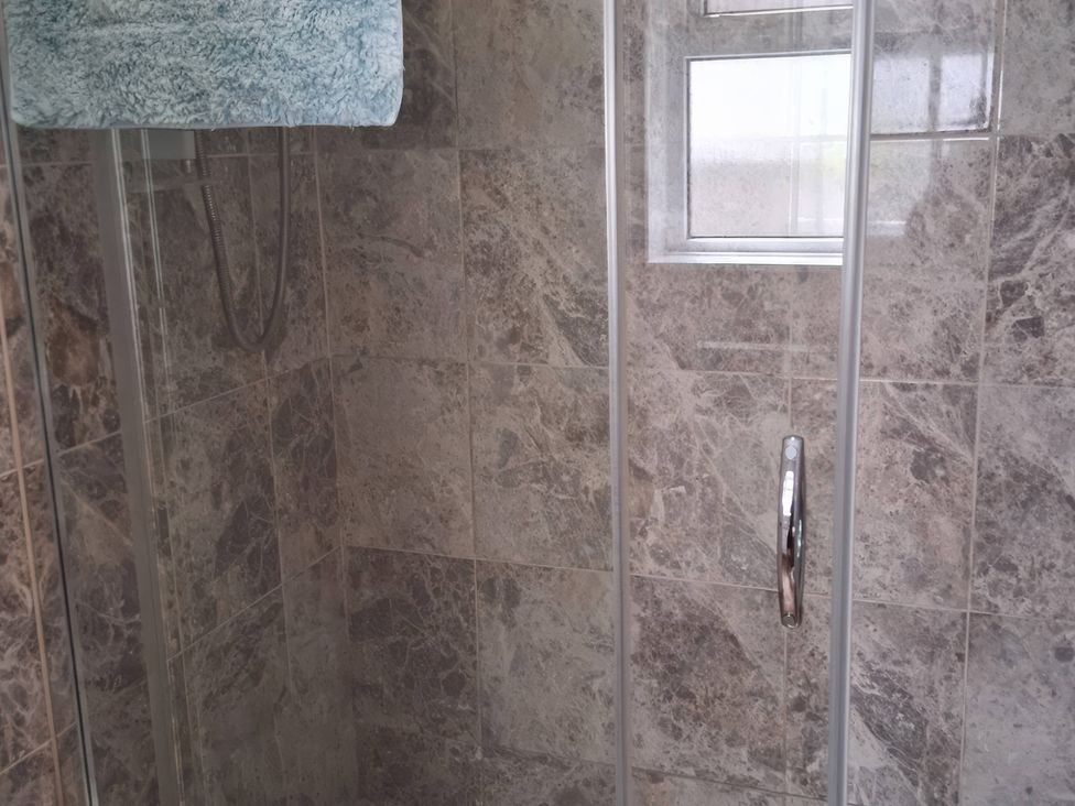A shower with tiles and a window at the property in Newbridge, Caerffili