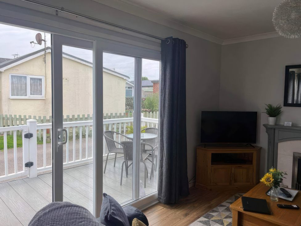 A living room with a sliding door and television at Seaside Escape 2Br Sleeps4 Parking PetsOK Fireplace in Bridlington