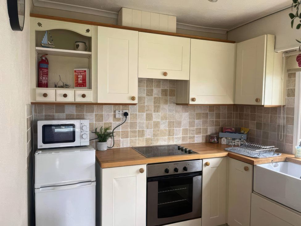 A kitchen with cabinets and appliances at Seaside Escape 2Br Sleeps4 Parking PetsOK Fireplace in Bridlington