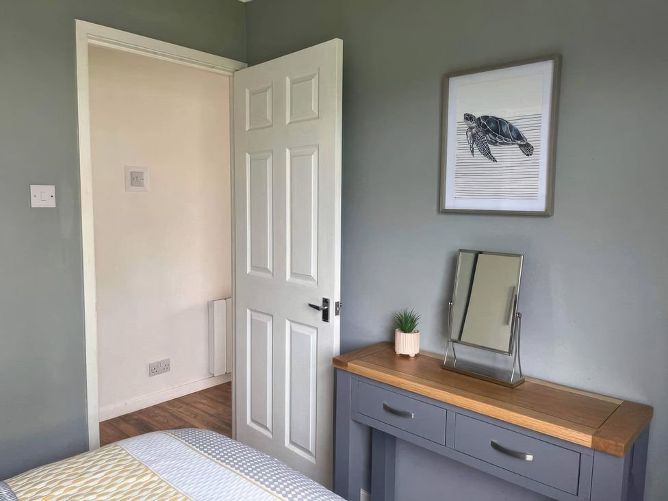 A bedroom with a mirror and a picture on the wall at Seaside Escape 2Br Sleeps4 Parking PetsOK Fireplace in Bridlington