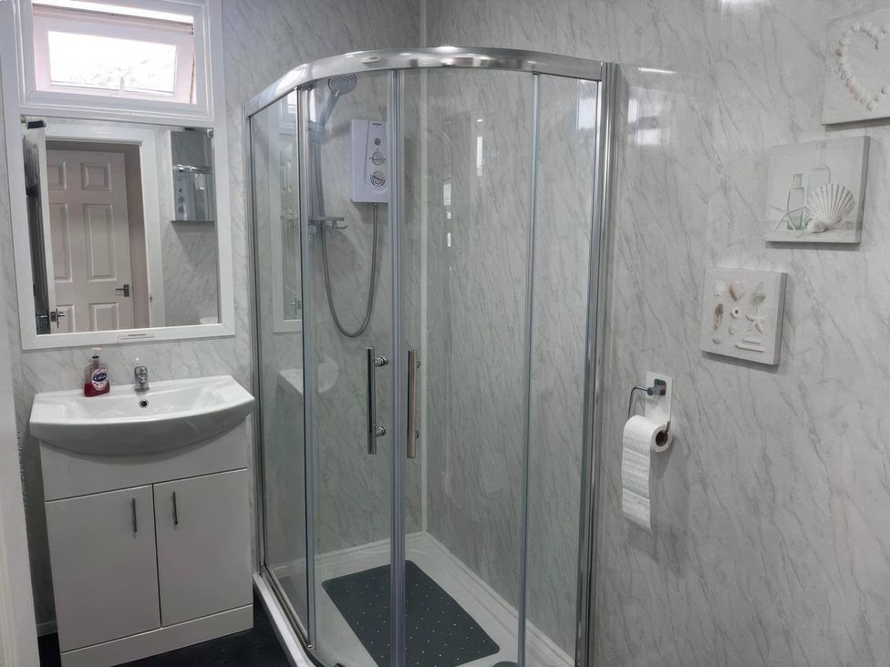 A bathroom with a shower, sink, and mirror at Seaside Escape 2Br Sleeps4 Parking PetsOK Fireplace in Bridlington
