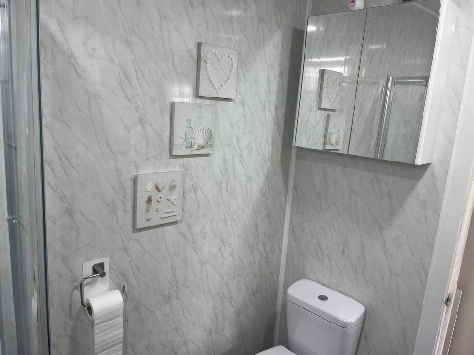 A bathroom with a toilet, sink, and mirror at Seaside Escape 2Br Sleeps4 Parking PetsOK Fireplace in Bridlington