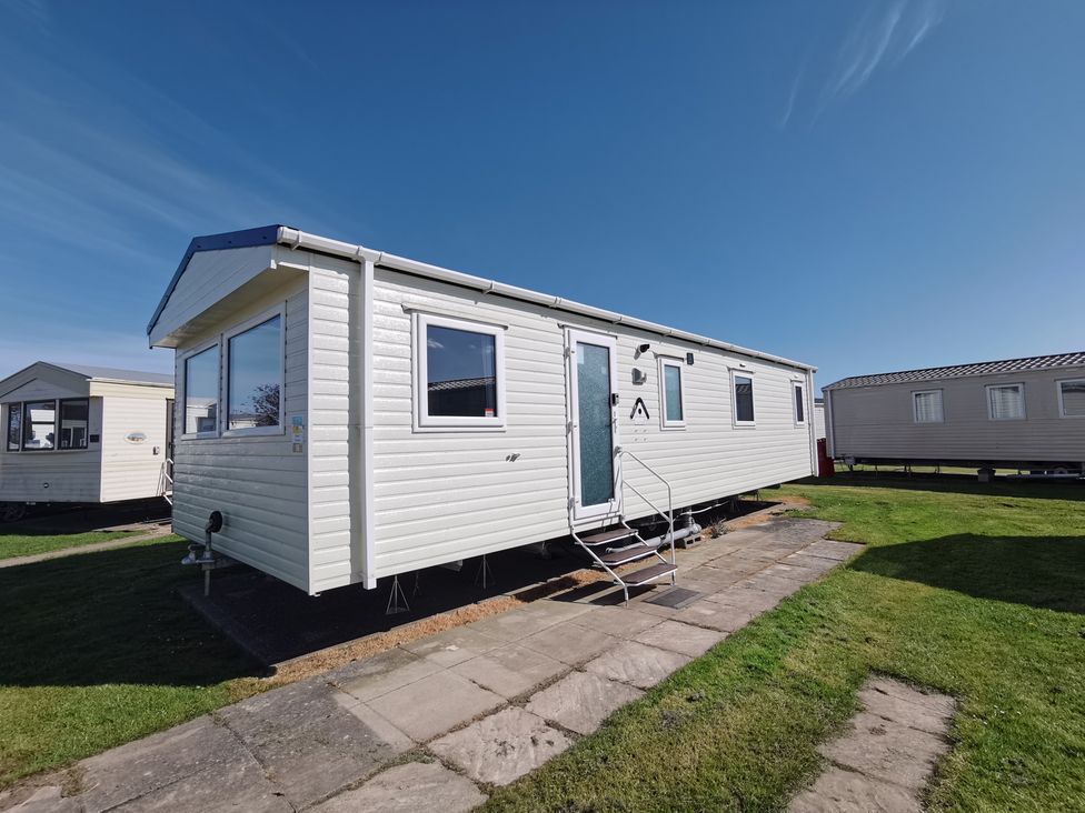A mobile home with steps in front at a caravan park