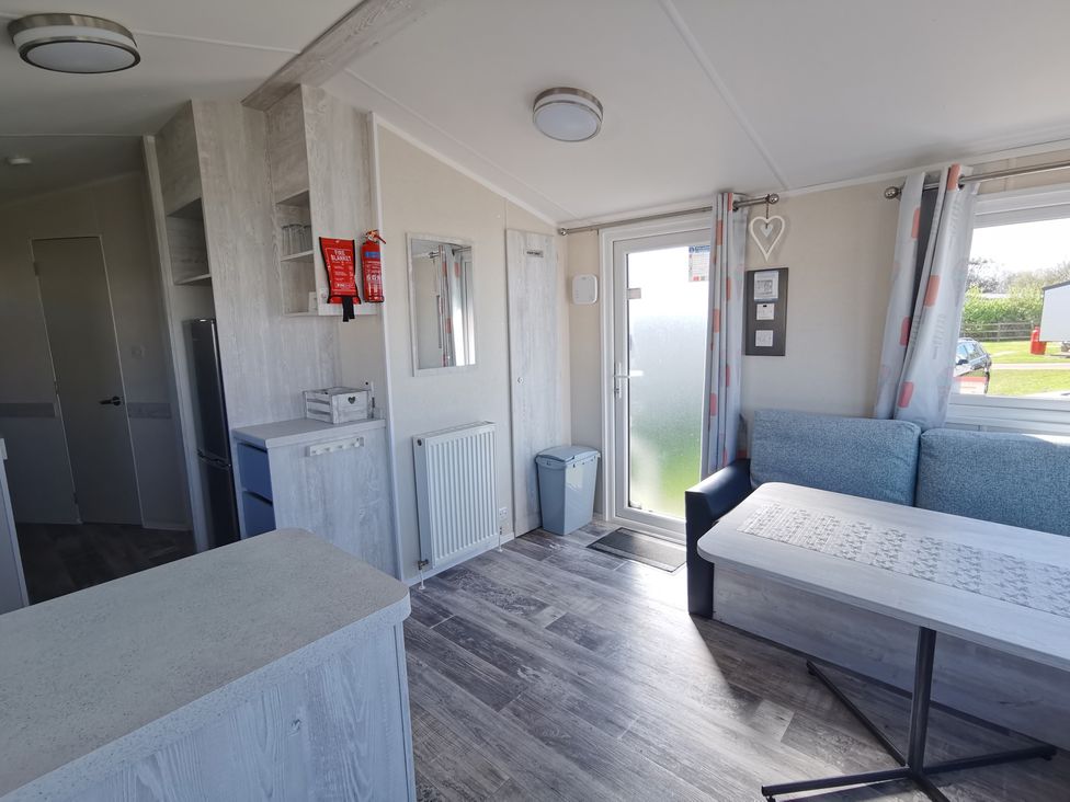 A living room with a couch and a table at a holiday cabin in an outdoor setting