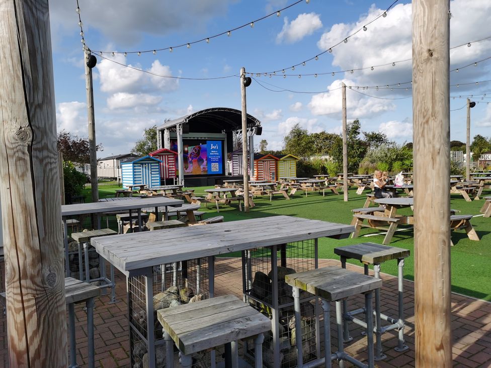 An outdoor area with a stage and picnic tables at an unspecified location
