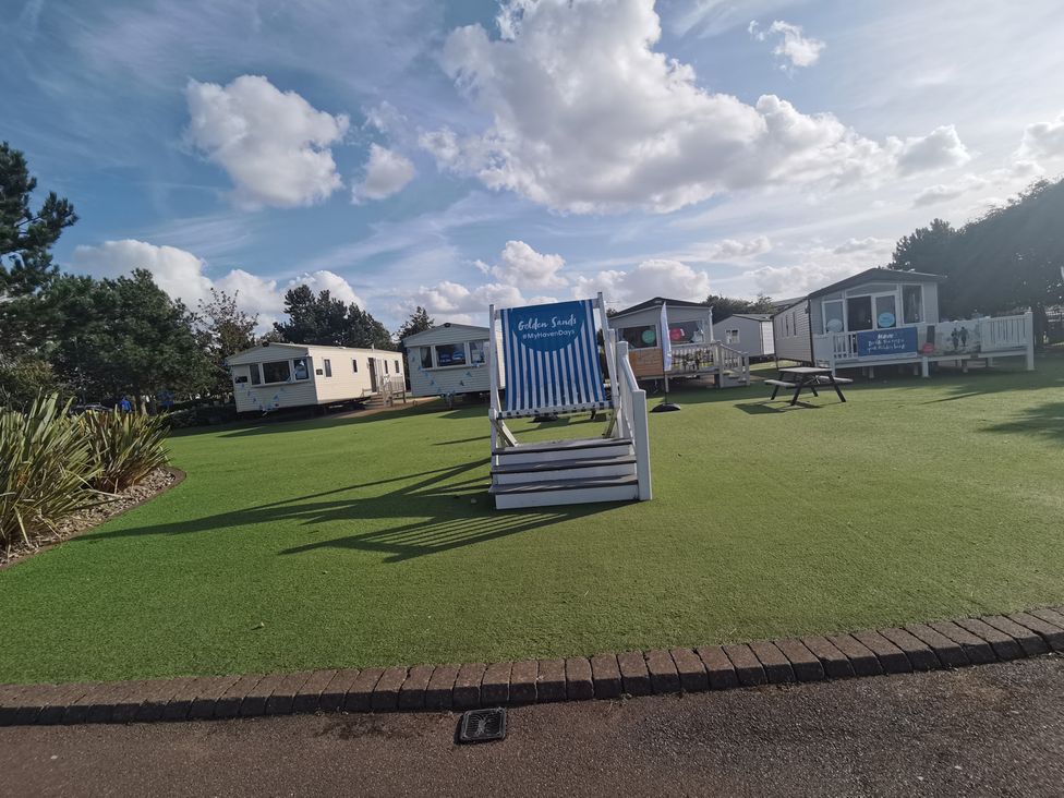 An outdoor area with caravans and seating at a holiday park