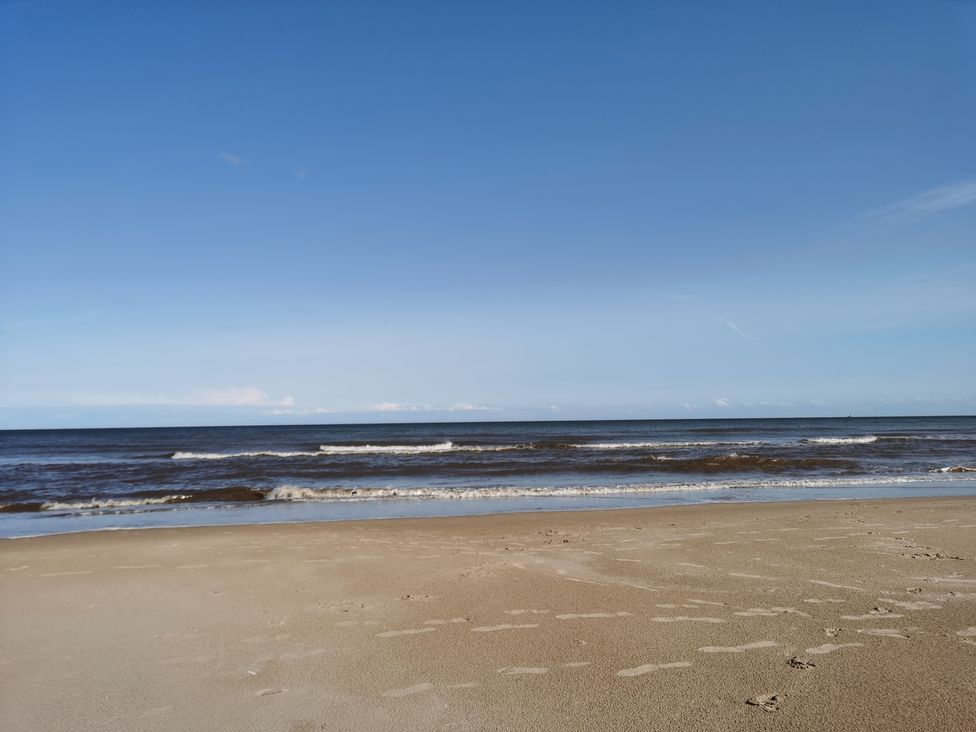 A beach with sand and waves at the ocean