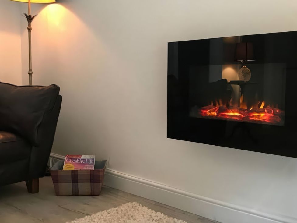A living room with a lamp and electric fireplace at Oakley Country Retreat1 Bed Garden Free Parking in Nantwich