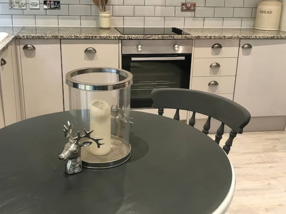 A kitchen with a round table, candle holder, and stainless steel oven at Oakley Country Retreat1 Bed Garden Free Parking, Nantwich