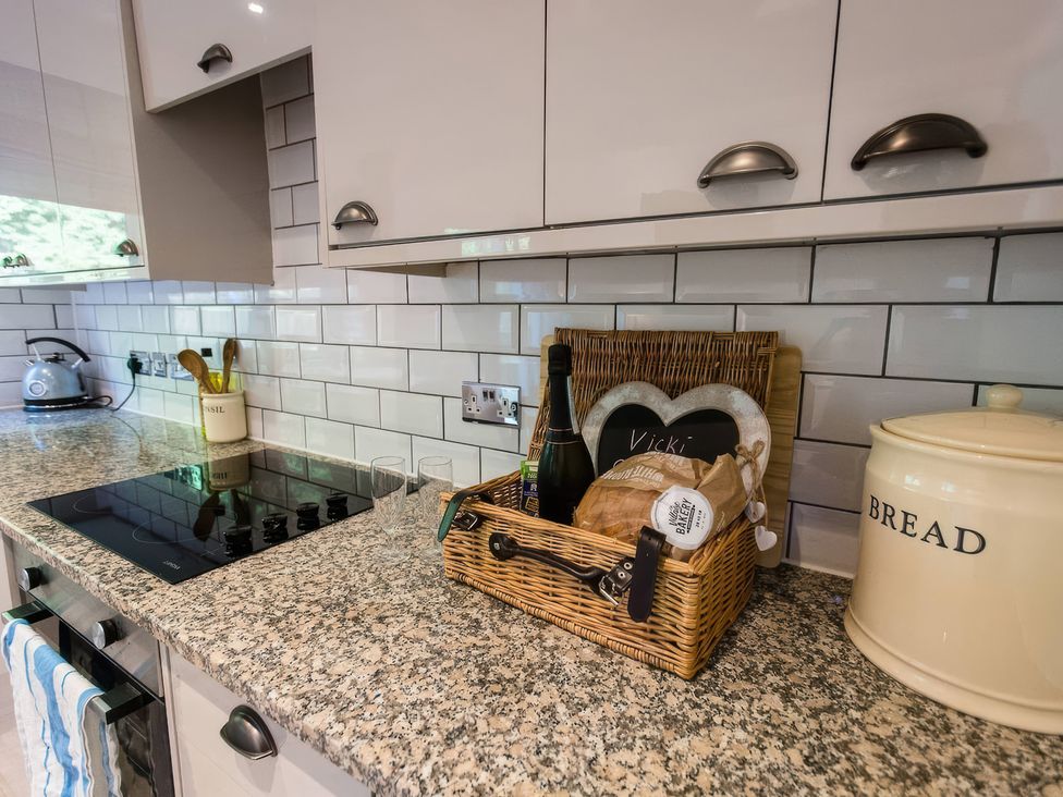 A kitchen with a basket and glasses on a granite countertop at Oakley Country Retreat1 Bed Garden Free Parking Nantwich