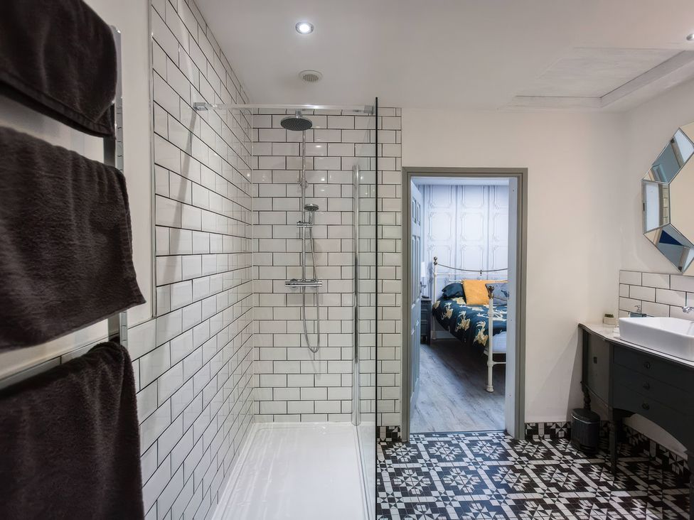 A bathroom with a shower, towels and a door leading to a bedroom at Oakley Country Retreat1 Bed Garden Free Parking Nantwich