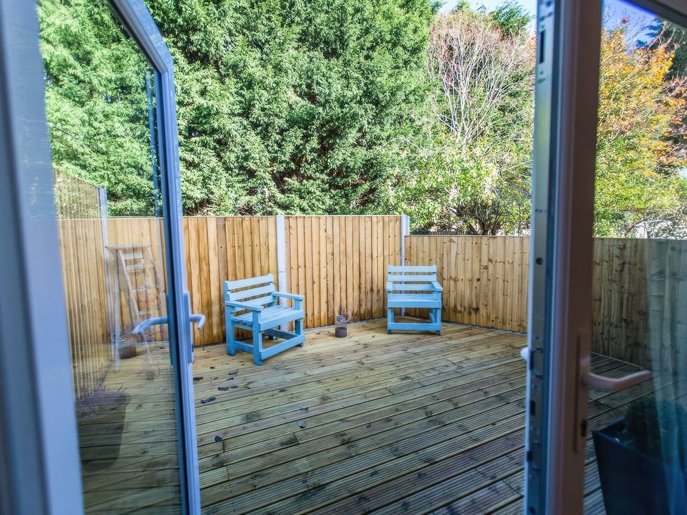 A garden with wooden decking and blue chairs at Oakley Country Retreat1 Bed Garden Free Parking Nantwich