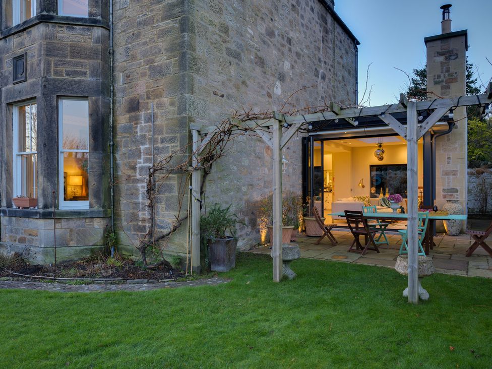 A garden with outdoor furniture and stone wall at the property