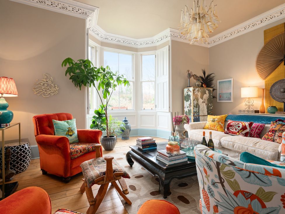 A living room with a sofa, armchair, and coffee table at The Old Barn in Manchester