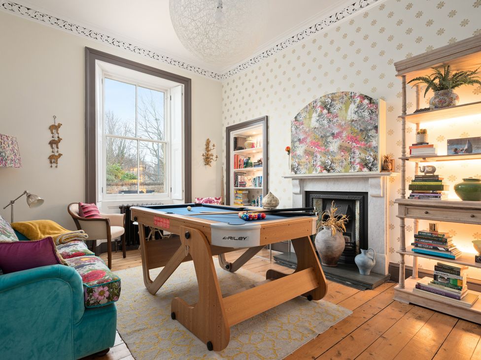 A living room with a pool table and bookshelf at a private residence