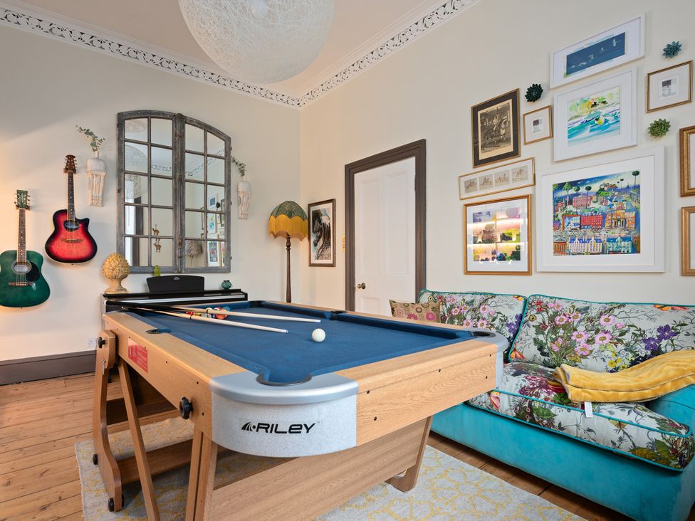 A game room with a pool table and guitars on the wall at The Old Barn in Manchester