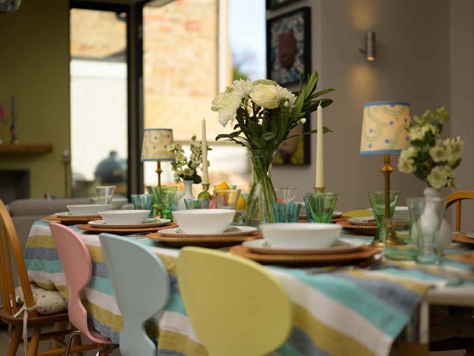 A dining room table set with dishes and flowers at The Old Barn in Manchester