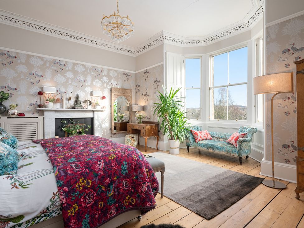 A bedroom with a bed and large windows at The Old Barn in Manchester