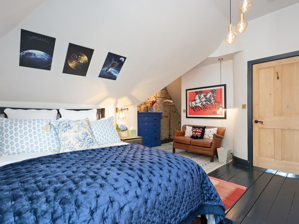 A bedroom with a bed, nightstand, and artwork at The Old Barn in Manchester