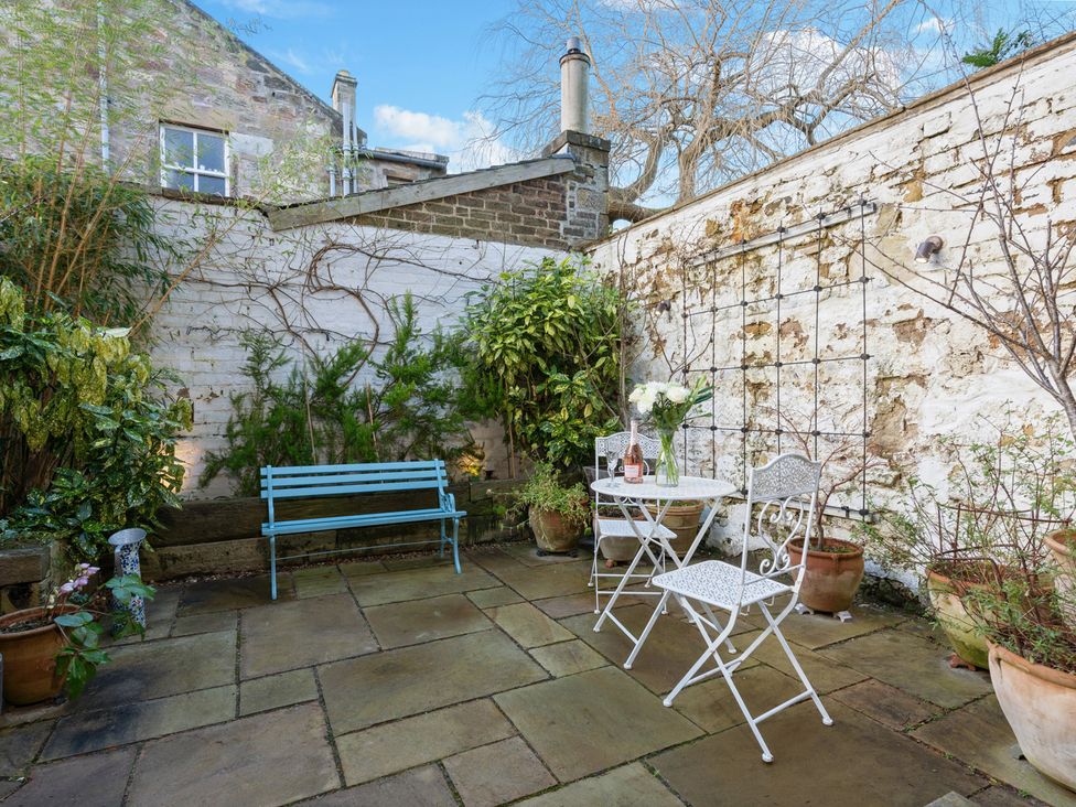A garden with a table, chairs and plants at a property